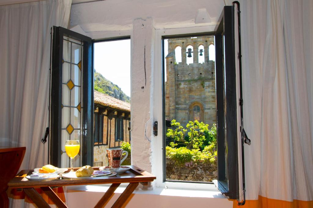 une table en face d'une fenêtre avec vue sur un bâtiment dans l'établissement Hotel Posada Santa Maria la Real, à Aguilar de Campoo