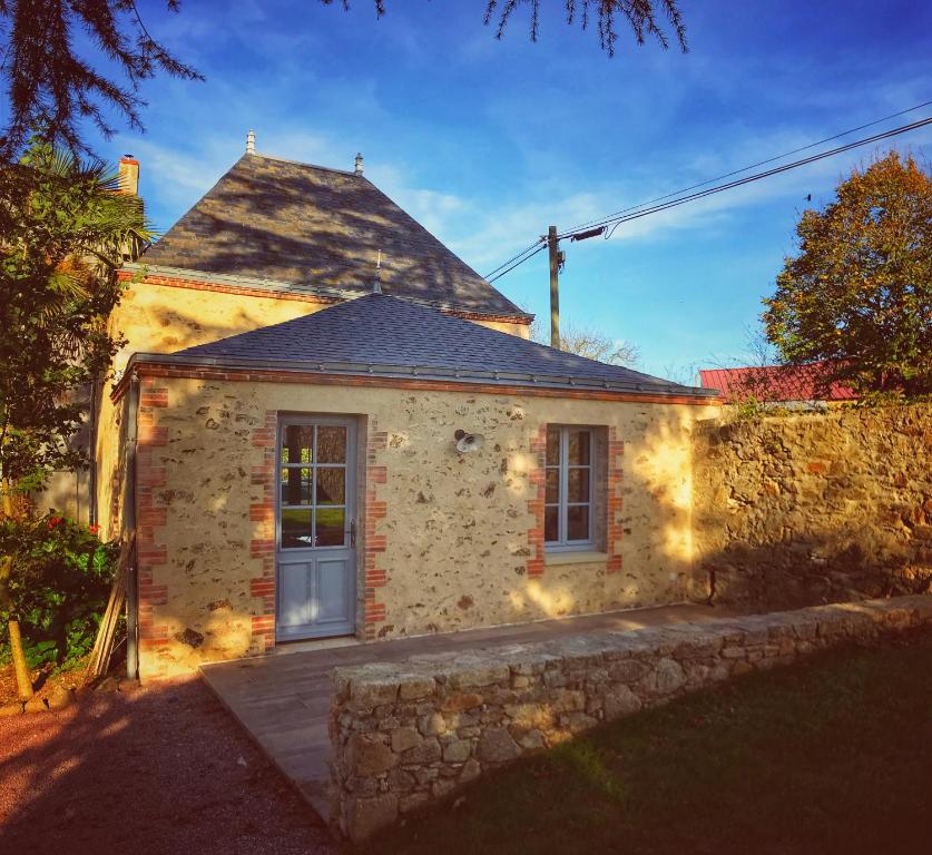 une petite maison en pierre avec un mur en pierre dans l'établissement La Mauriere - Puy du Fou, à Saint-Michel-Mont-Mercure