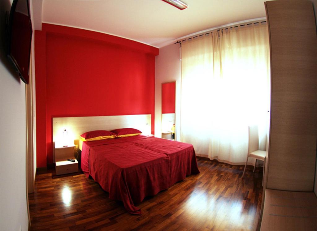 czerwona sypialnia z łóżkiem z czerwoną ścianą w obiekcie B&B Santa Caterina w mieście Reggio di Calabria
