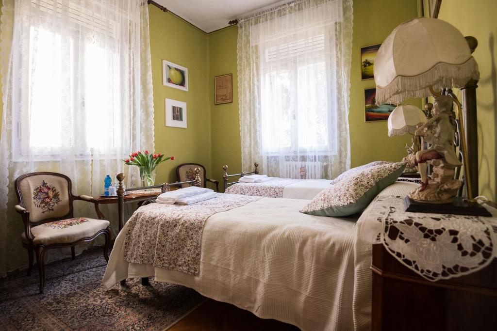 1 dormitorio con 2 camas y mesa con lámpara en B&B Pereuka, en Rovigo