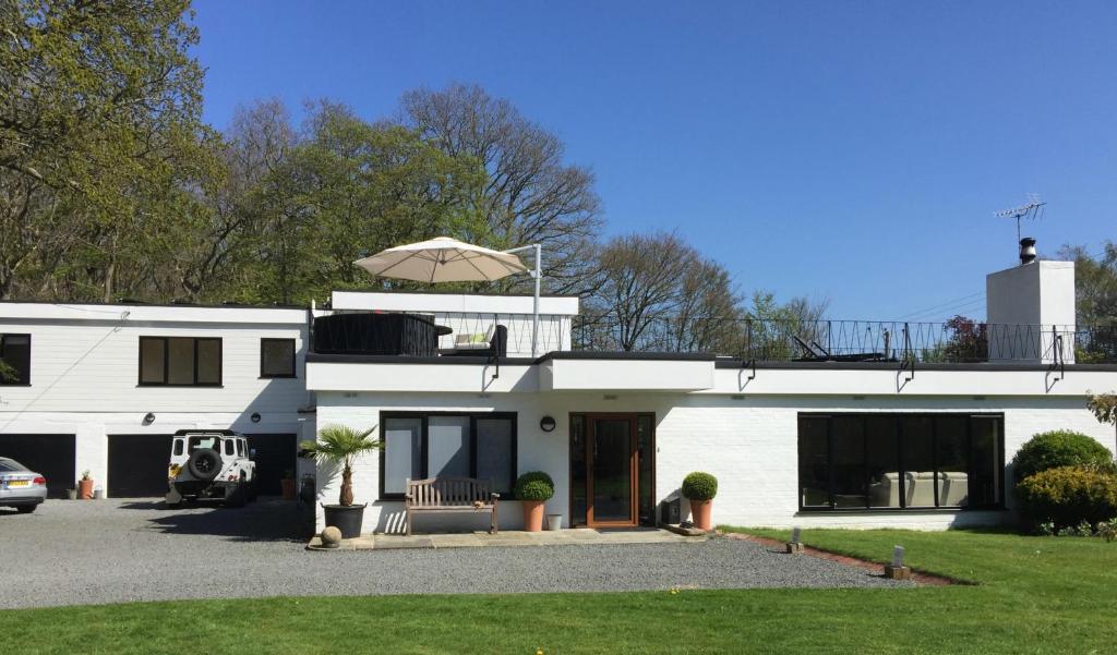 a white house with an umbrella on top of it at White Lodge B&B in Cooksbridge