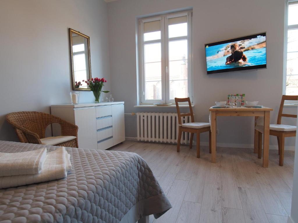 グダニスクにあるGrand Tourist Geminiのベッドルーム1室(ベッド1台、テーブル、壁掛けテレビ付)