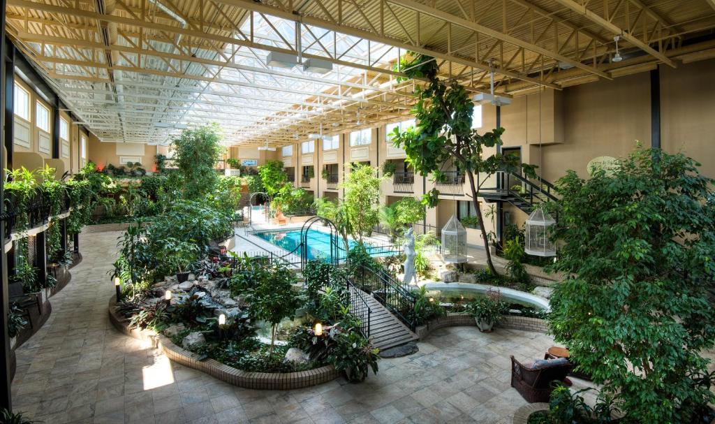 um grande edifício com plantas e uma piscina em Hotel L'Oiseliere Montmagny em Montmagny