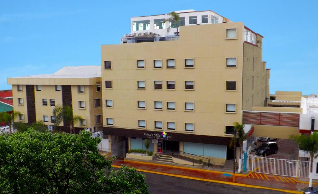 a tall tan building with a building at Hotel Campestre Inn in León