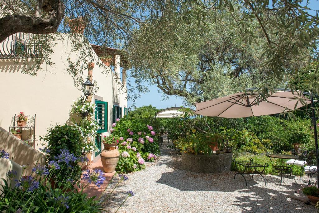 a garden with an umbrella and some flowers at B&B Don Gaspano in Milazzo