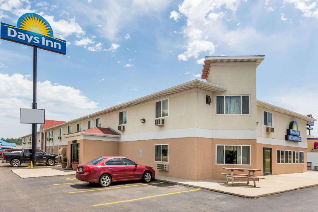 un hotel con un coche rojo estacionado en un estacionamiento en Days Inn by Wyndham Sioux City, en Sioux City