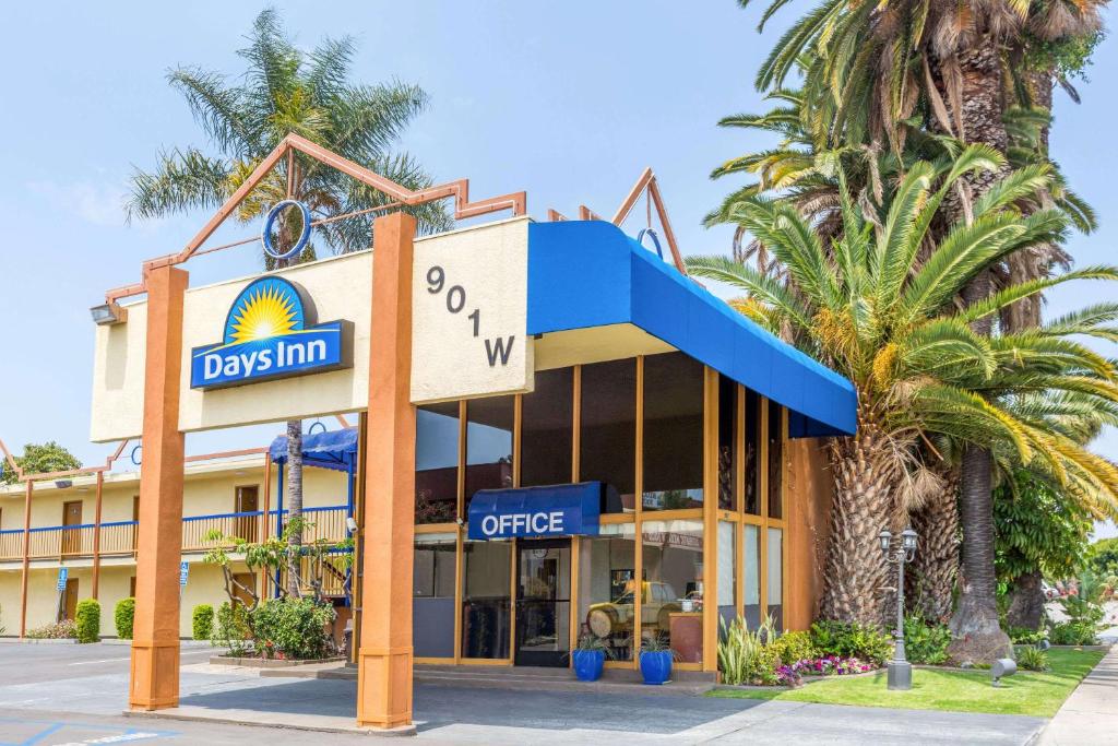 a building with a sign that reads dogs inn coffee at Days Inn by Wyndham Los Angeles LAX/VeniceBch/Marina DelRay in Los Angeles