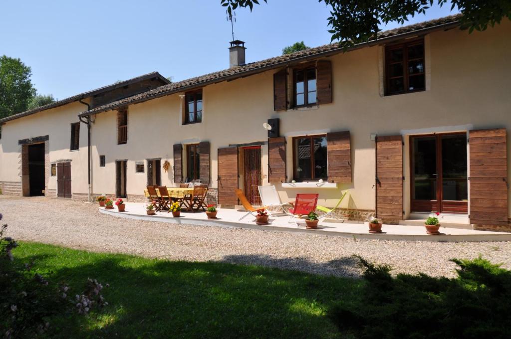 una casa con patio y sillas frente a ella en Ferme Passion, en Saint-Trivier-sur-Moignans