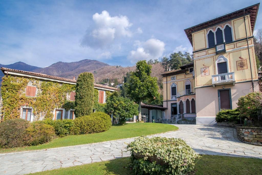 un grupo de edificios con montañas en el fondo en Villa Giù Luxury - The House Of Travelers, en Faggeto Lario 