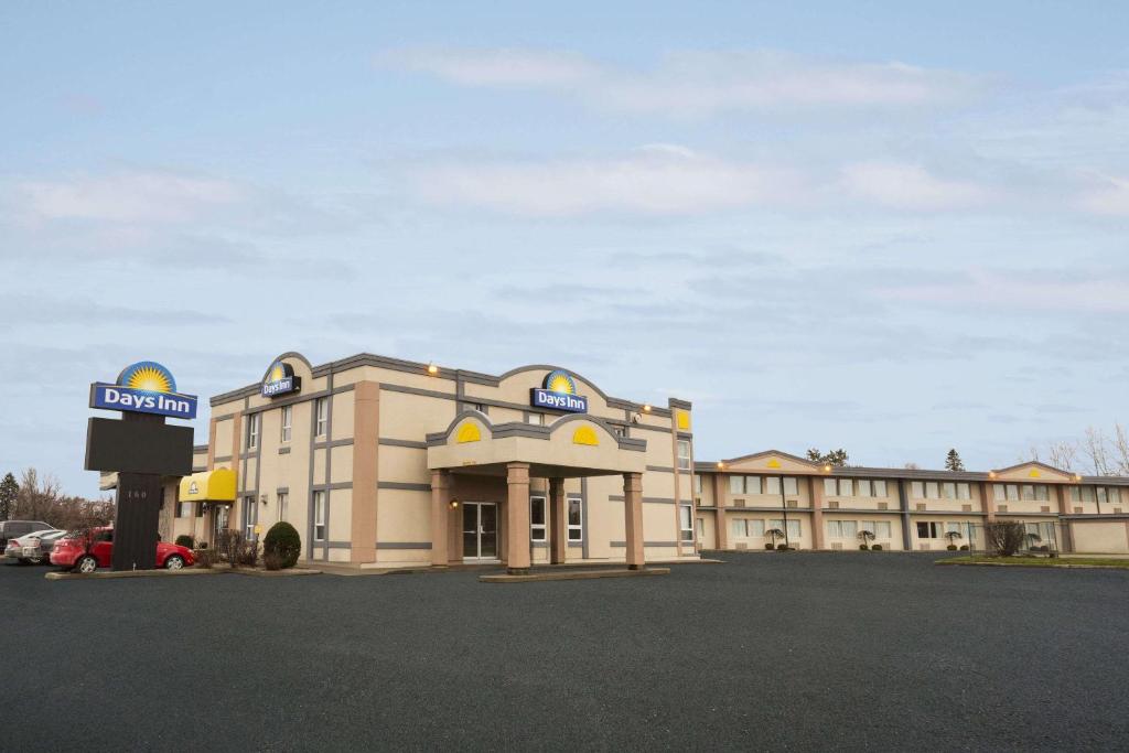 a hotel building with a sign in front of it at Days Inn by Wyndham Brockville in Brockville