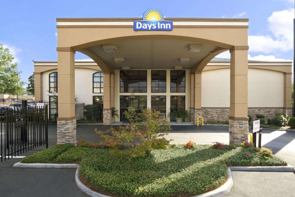 a day inn building with a sign on it at Days Inn & Suites by Wyndham Tuscaloosa - Univ. of Alabama in Tuscaloosa