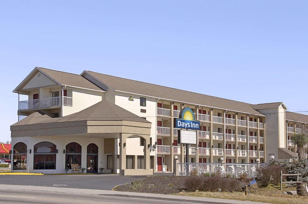 a hotel building with a hotel sign in front of it at Days Inn by Wyndham Apple Valley Pigeon Forge/Sevierville in Pigeon Forge
