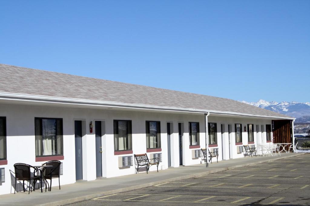 a building with chairs and tables in a parking lot at Retro Inn at Mesa Verde in Cortez