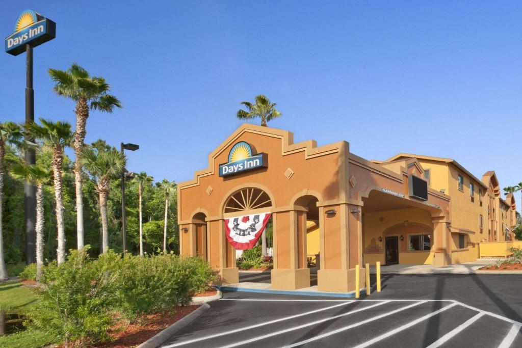 a building on a street with palm trees at Days Inn by Wyndham Orange Park/Jacksonville in Orange Park
