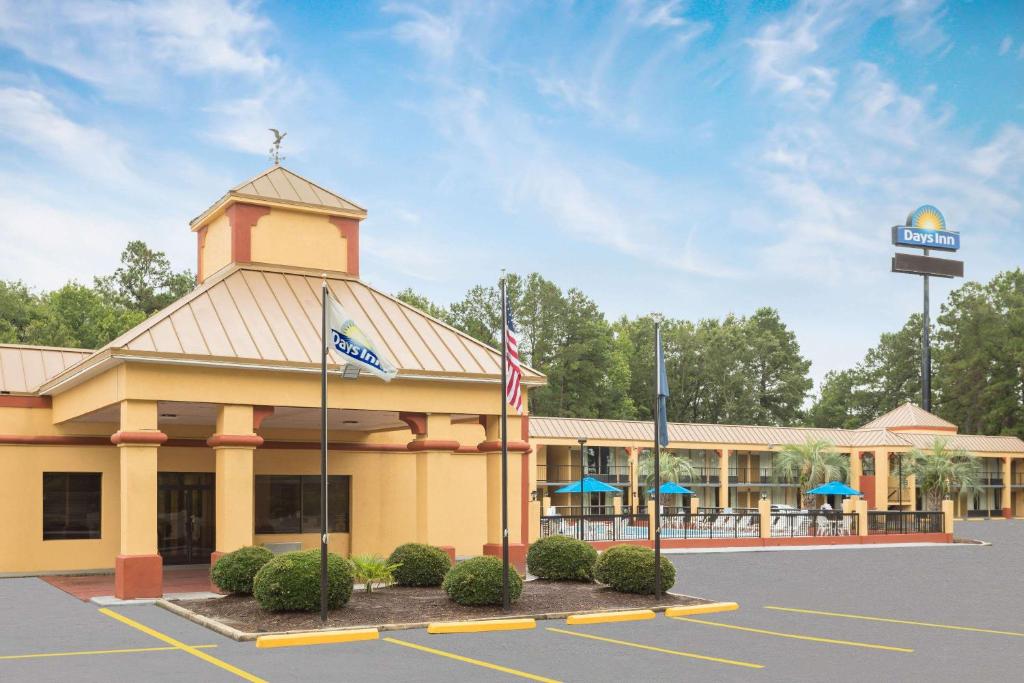 a large building with a sign in a parking lot at Days Inn by Wyndham Orangeburg South in Orangeburg