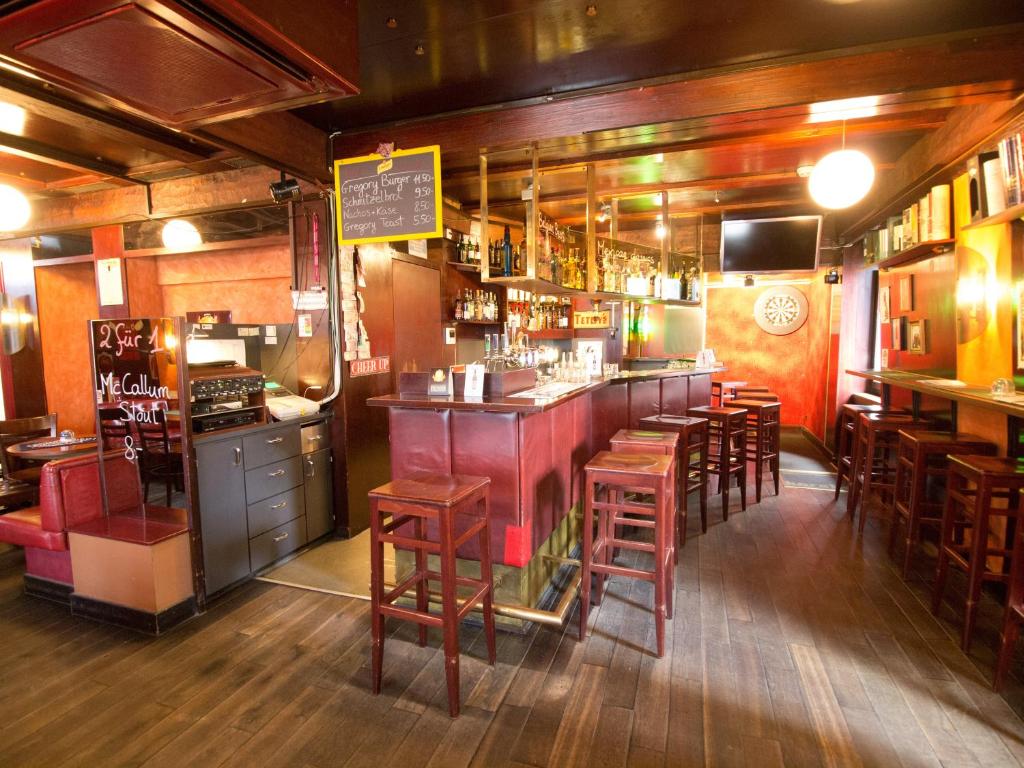 a bar with wooden stools in a restaurant at Hotel Gregory in Zürich