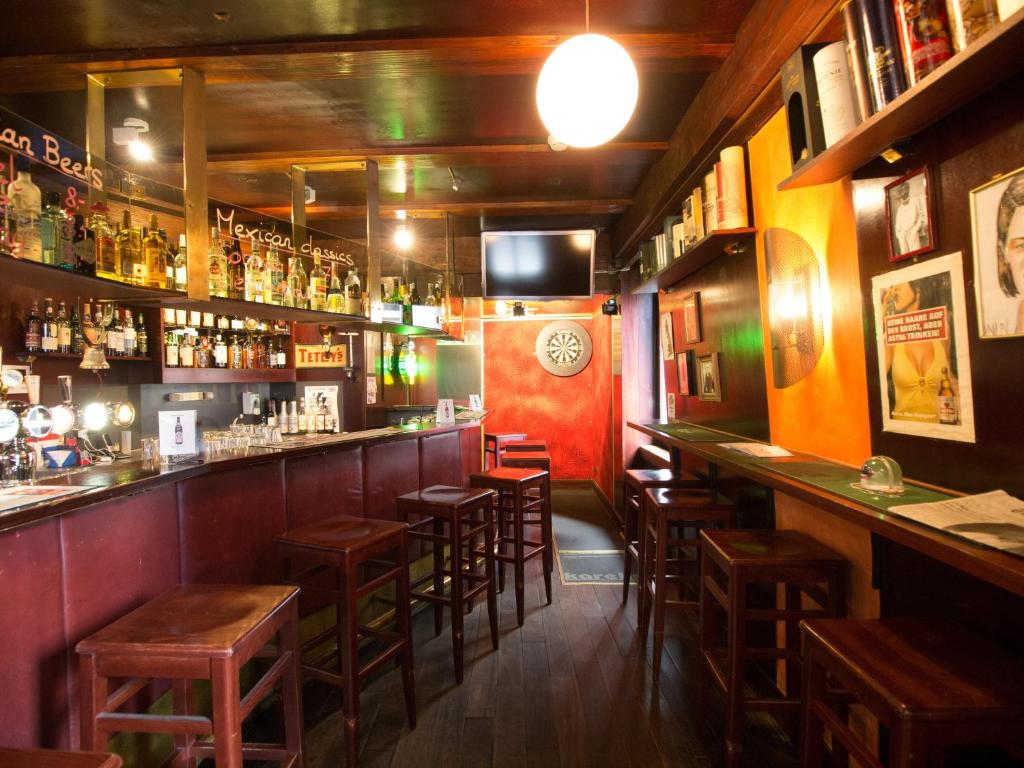 a bar with wooden stools in a restaurant at Hotel Gregory in Zürich