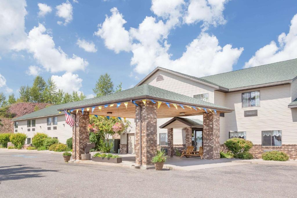 una casa con una bandera americana delante de ella en Days Inn by Wyndham Iron Mountain en Iron Mountain