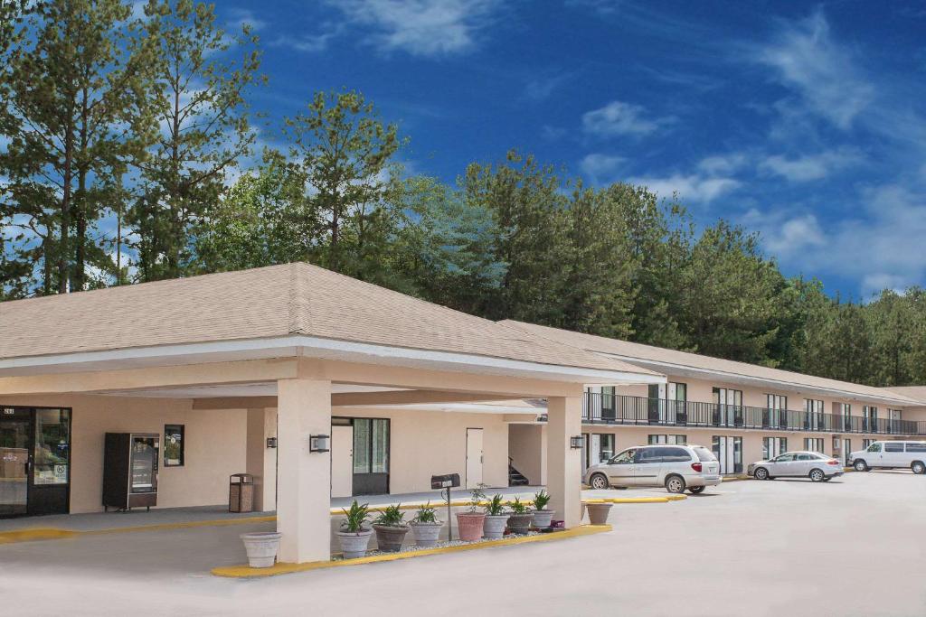 a building with cars parked in a parking lot at Days Inn by Wyndham Newton in Newton