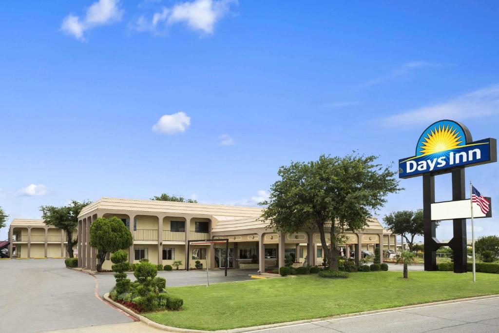 un panneau d'auberge devant un bâtiment dans l'établissement Days Inn by Wyndham Dallas Irving, à Irving