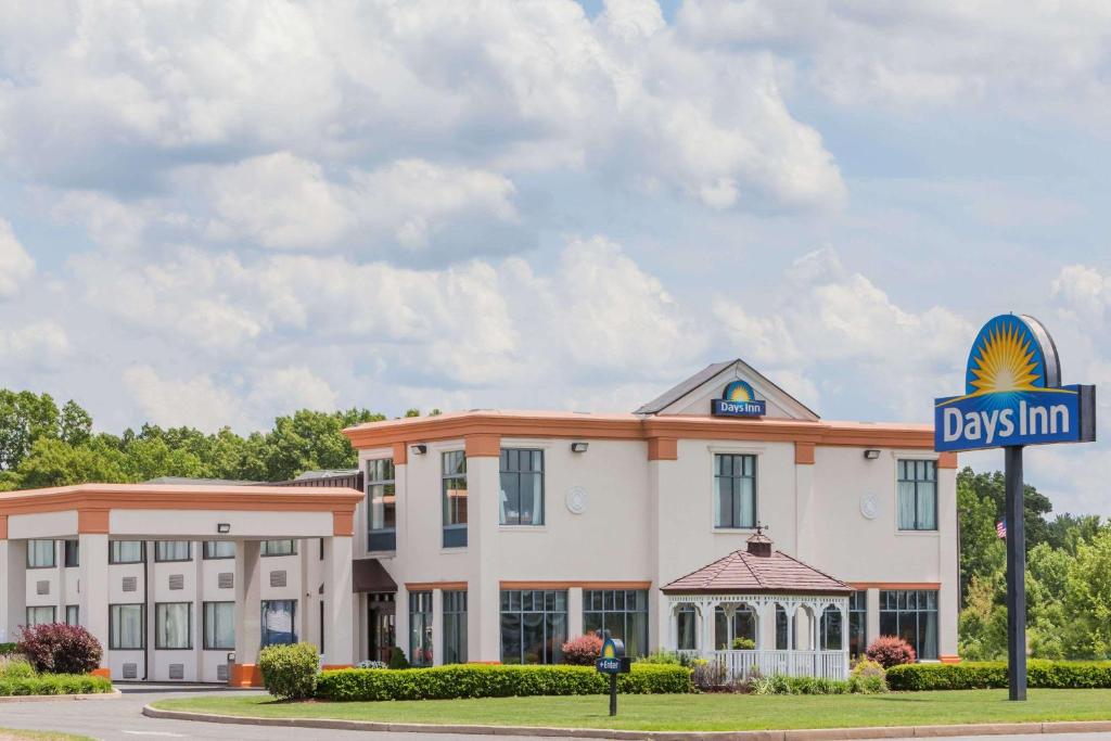 um hotel com uma placa em frente a um edifício em Days Inn by Wyndham Windsor Locks / Bradley Intl Airport em Windsor Locks