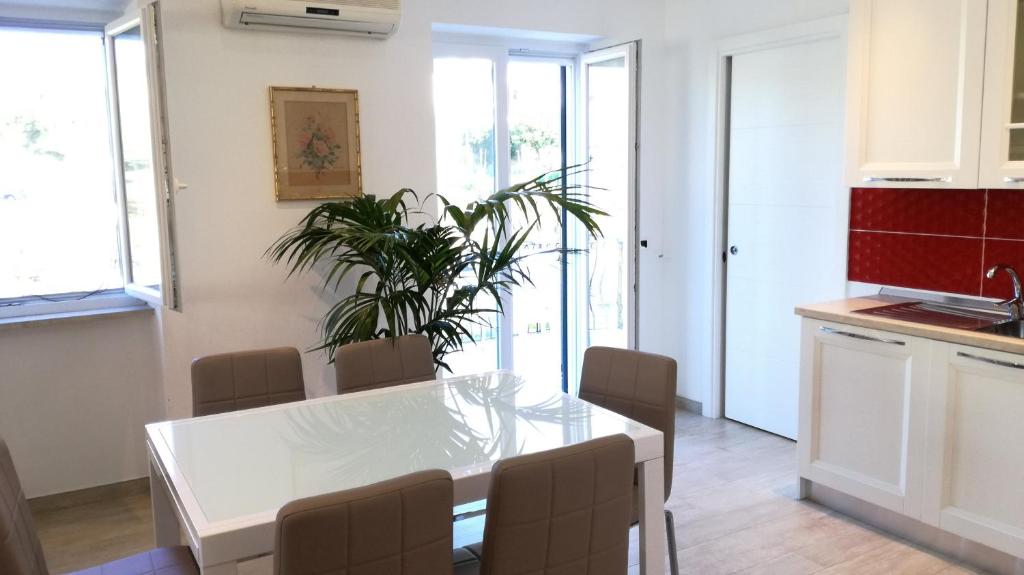 a kitchen and dining room with a white table and chairs at Casa delle Sirene in Ischia