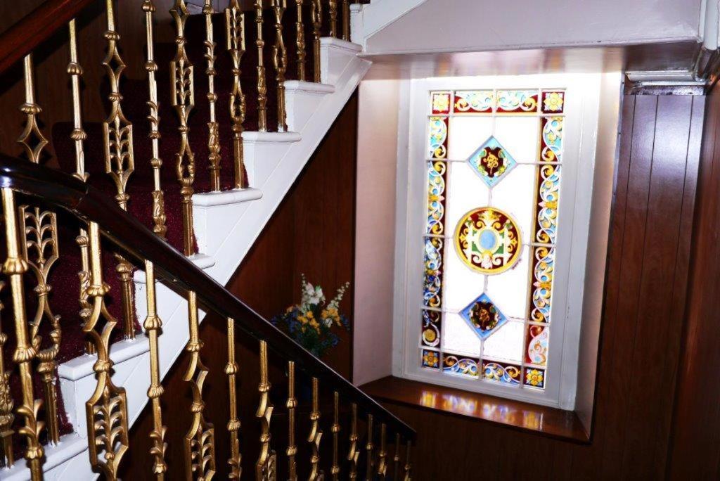 a staircase with a stained glass window on the wall at Elgin Guest House in Elgin