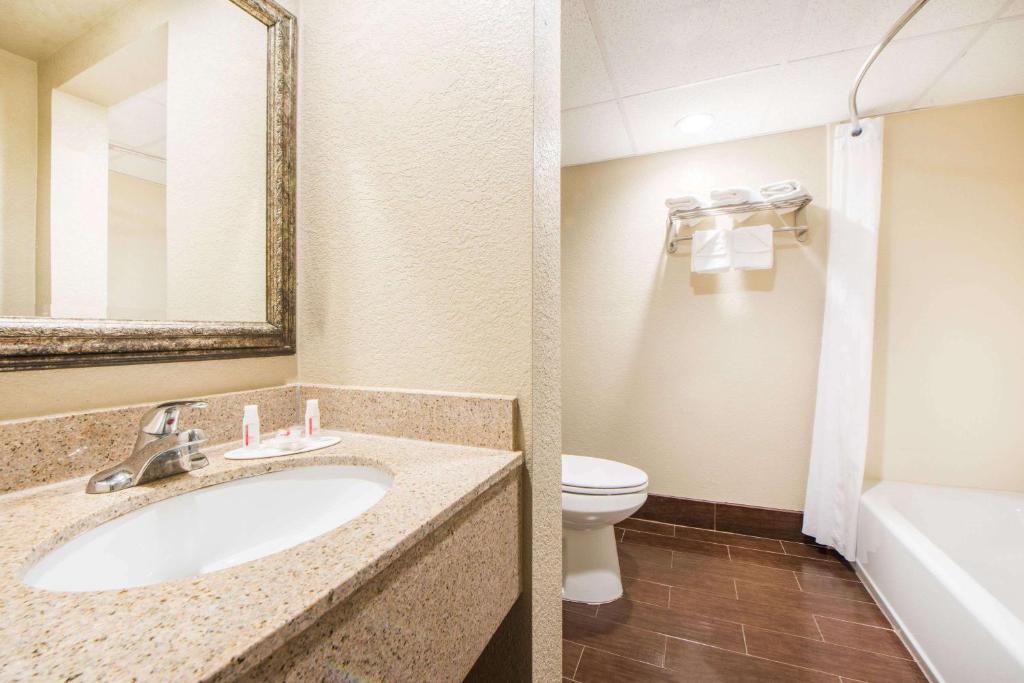 a bathroom with a sink and a toilet at Days Inn by Wyndham Joplin in Joplin