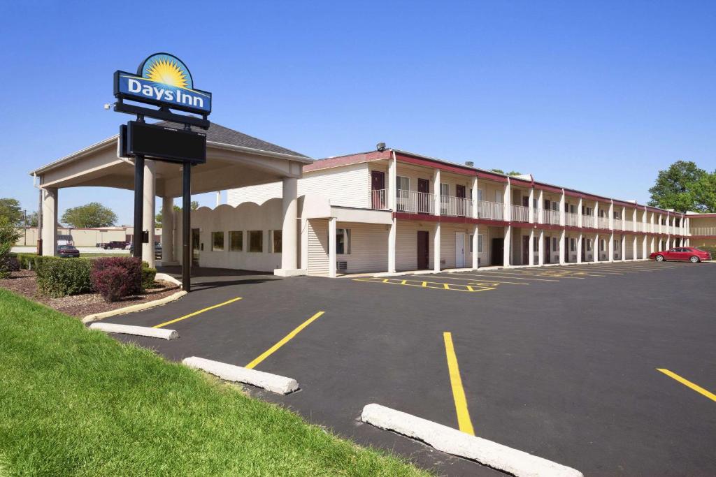 un hotel con un estacionamiento delante de él en Days Inn by Wyndham Champaign/Urbana en Champaign