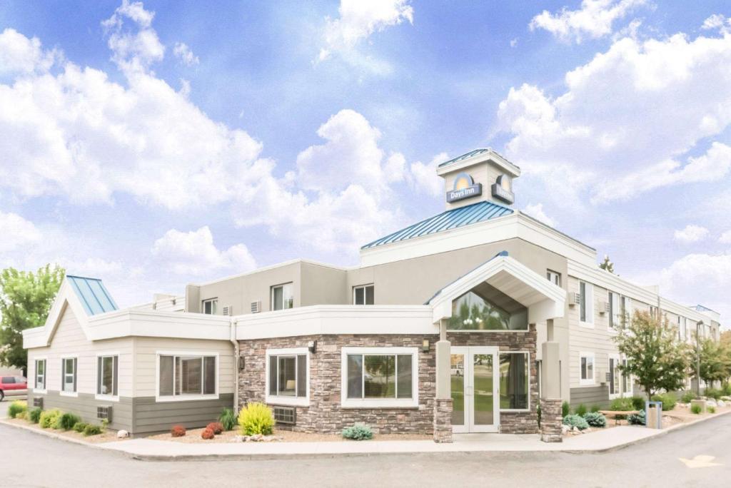 un grande edificio bianco con una torre dell'orologio in cima di Days Inn by Wyndham Bismarck a Bismarck