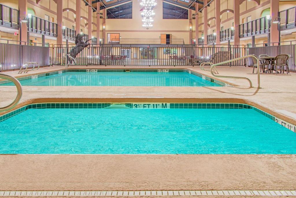 a large swimming pool in a building with blue water at Days Inn by Wyndham Lubbock South in Lubbock