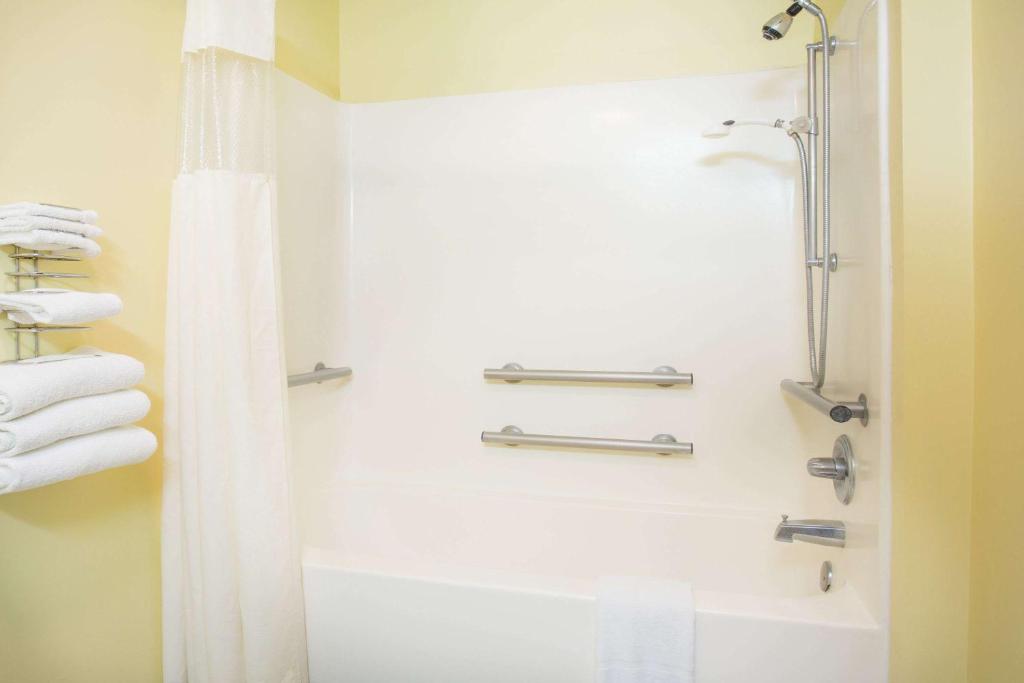 a bathroom with a shower and a bath tub at Days Inn by Wyndham Lexington NE in Lexington