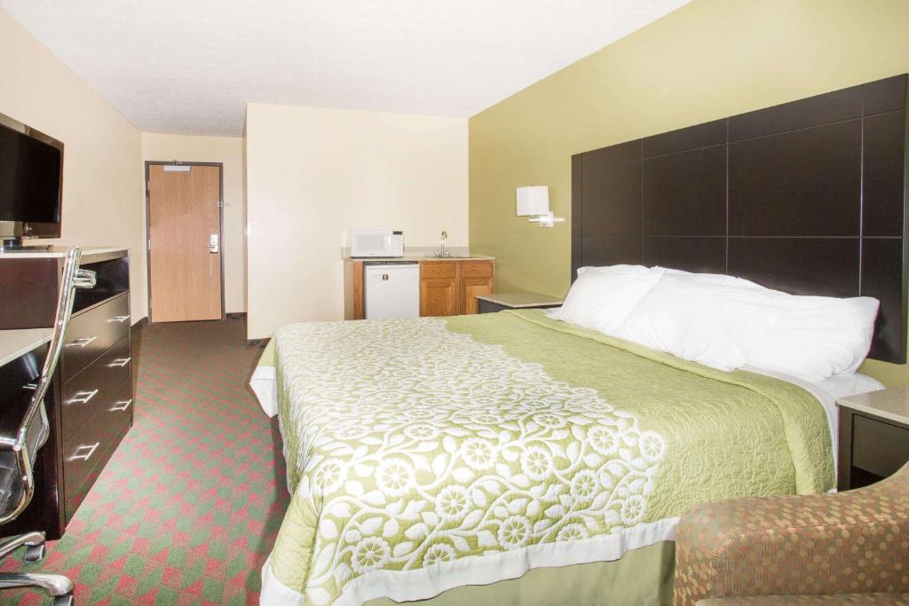a hotel room with a large bed and a television at Days Inn by Wyndham Lexington NE in Lexington
