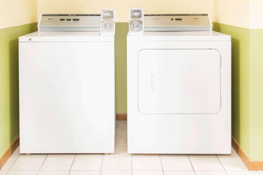 two white washing machines sitting next to each other at Days Inn by Wyndham Lexington NE in Lexington