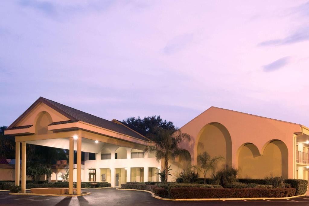 a building with a palm tree in front of it at Days Inn by Wyndham Crystal River in Crystal River