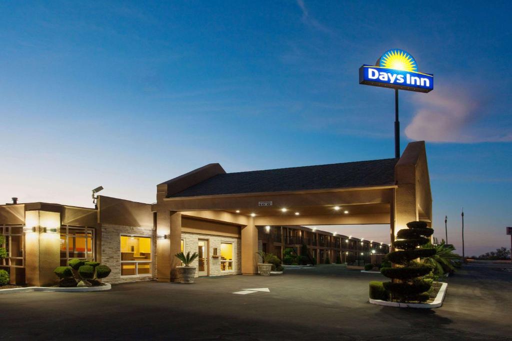 a days inn sign in front of a building at Days Inn by Wyndham Chowchilla Gateway to Yosemite in Chowchilla