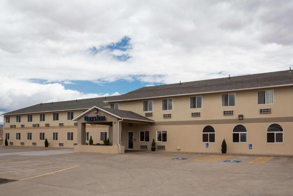 a large building with a parking lot in front of it at Days Inn by Wyndham Hurricane/Zion National Park Area in Hurricane