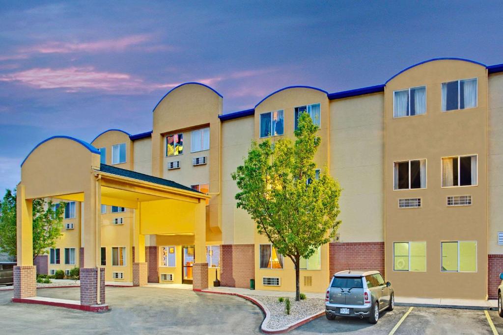 a building with a car parked in a parking lot at Days Inn by Wyndham Lehi in Lehi