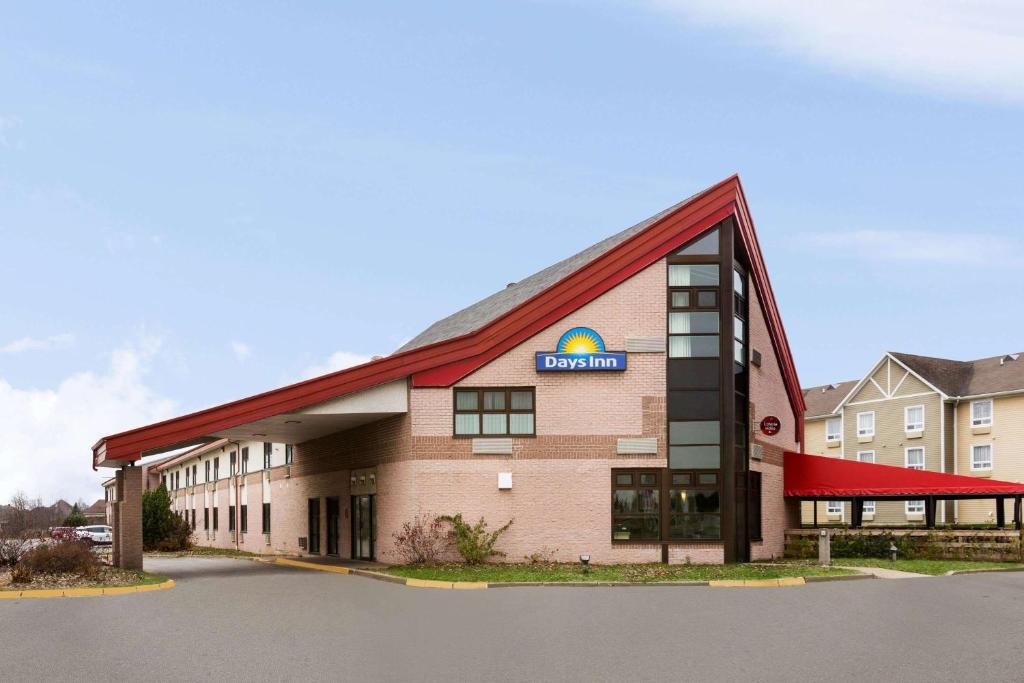 a hotel building with a sign on the front of it at Days Inn by Wyndham Trois-Rivieres in Trois-Rivières