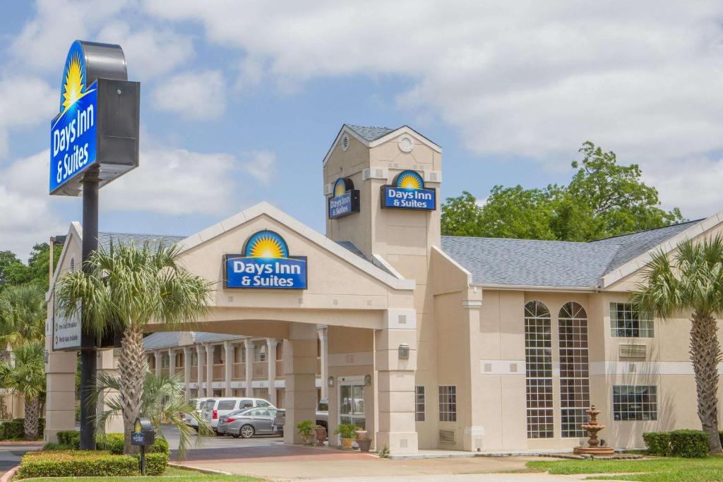 a large building with a dogs inn and suites at Days Inn by Wyndham Nacogdoches/SFA University/Downtown in Nacogdoches