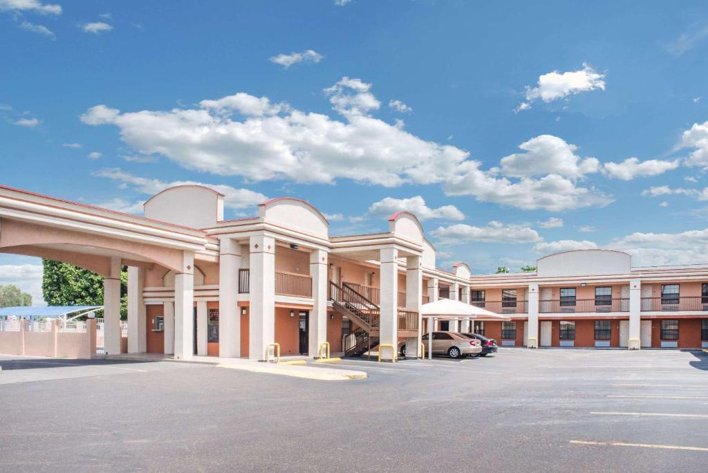 a large building with a car parked in a parking lot at Days Inn by Wyndham McAllen in McAllen