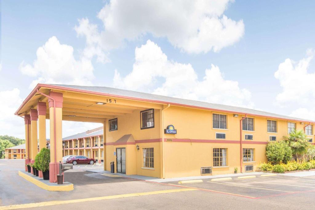 a large yellow building with a parking lot at Days Inn & Suites by Wyndham Marshall in Marshall