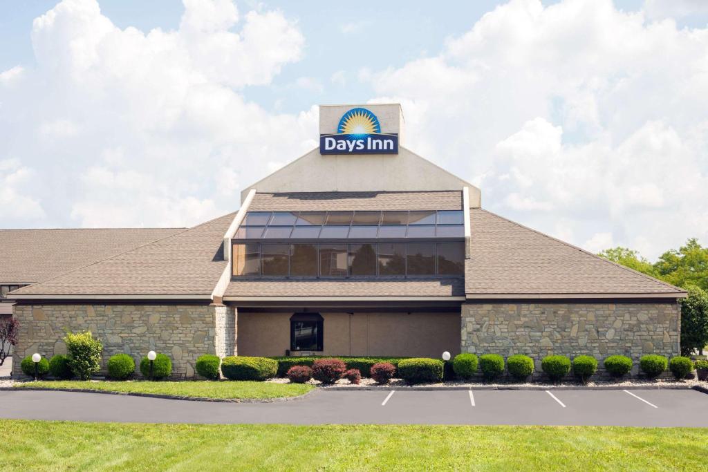 a view of adq inn building with a parking lot at Days Inn by Wyndham Maumee/Toledo in Maumee