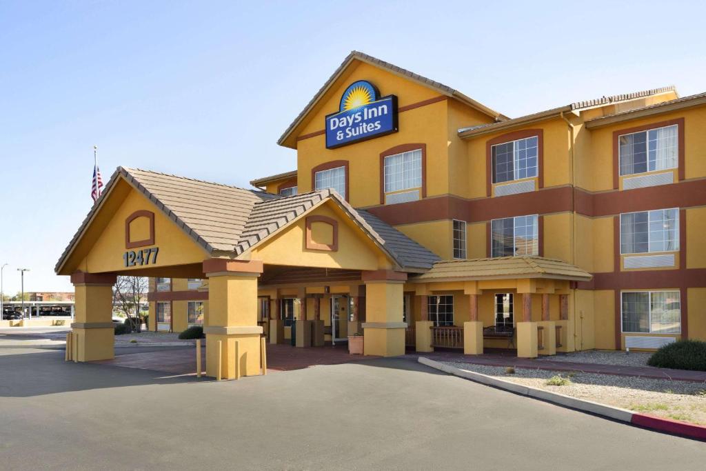 a large yellow building with a sign on it at Days Inn & Suites by Wyndham Surprise in Surprise
