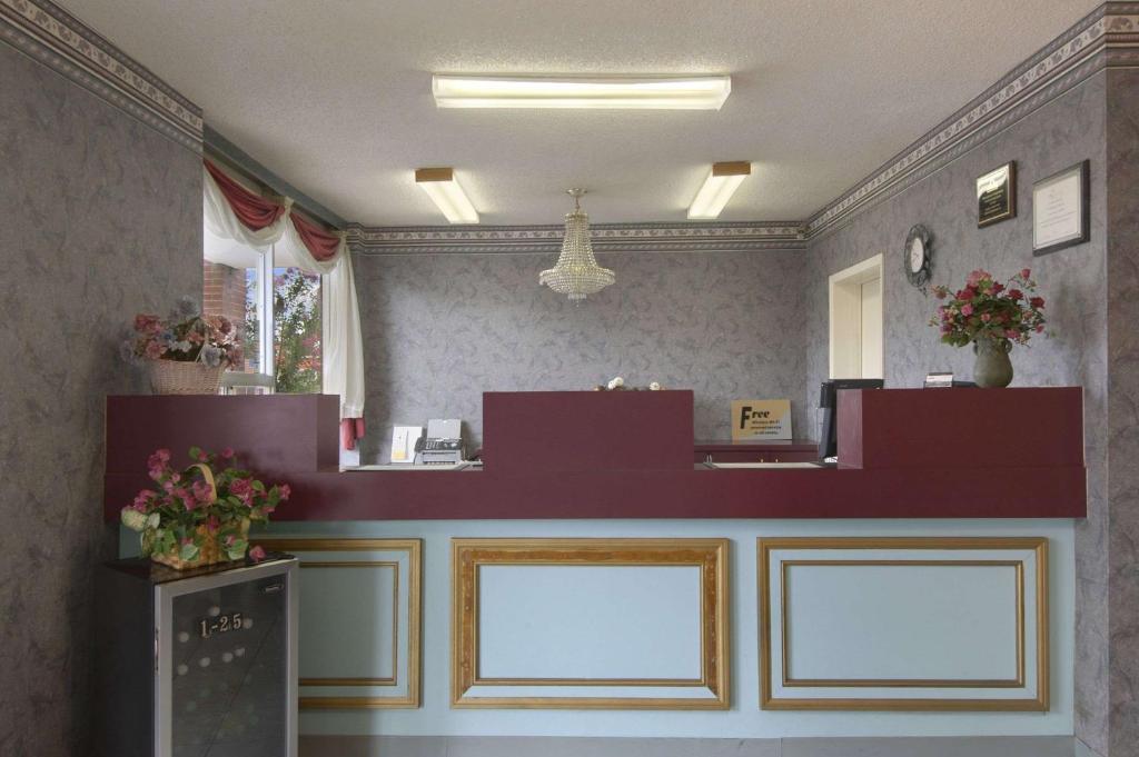 a waiting room with a counter with flowers on it at Days Inn by Wyndham Jonesboro AR in Jonesboro