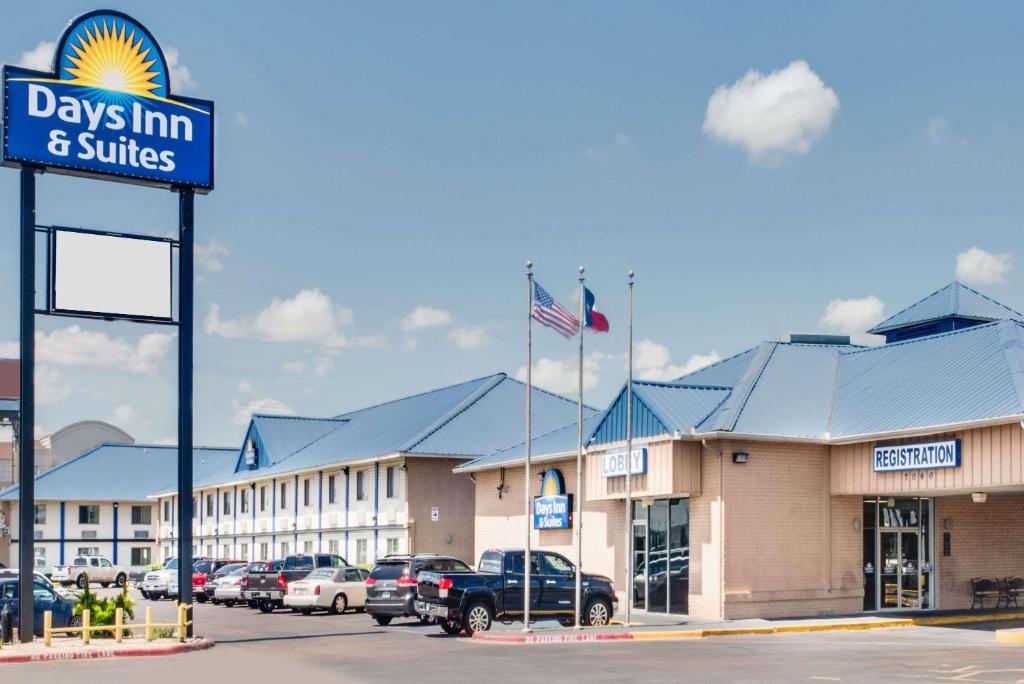 a days inn and suites sign in front of a dealership at Days Inn & Suites by Wyndham Laredo in Laredo