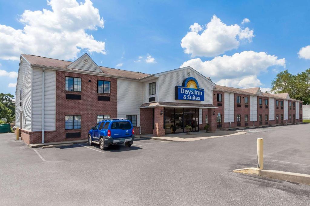 un hotel con un camión azul estacionado en un estacionamiento en Days Inn & Suites by Wyndham Cambridge en Cambridge