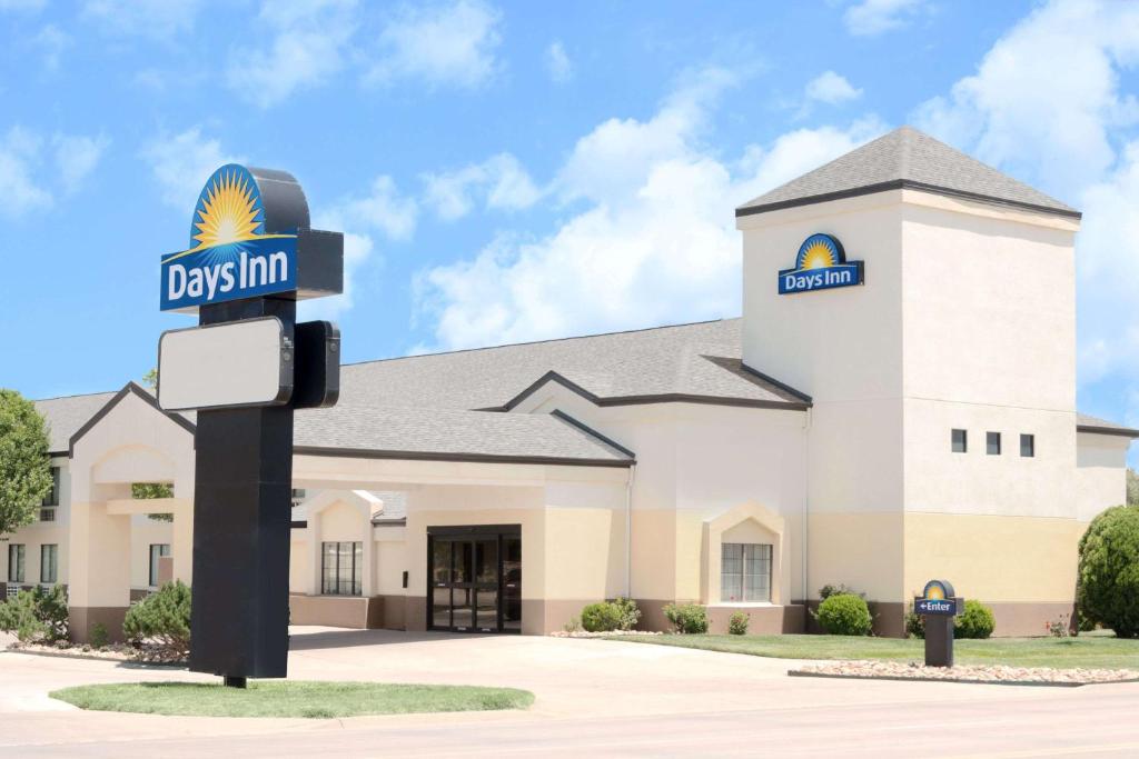 a large white building with a sign in front of it at Days Inn by Wyndham Liberal KS in Liberal