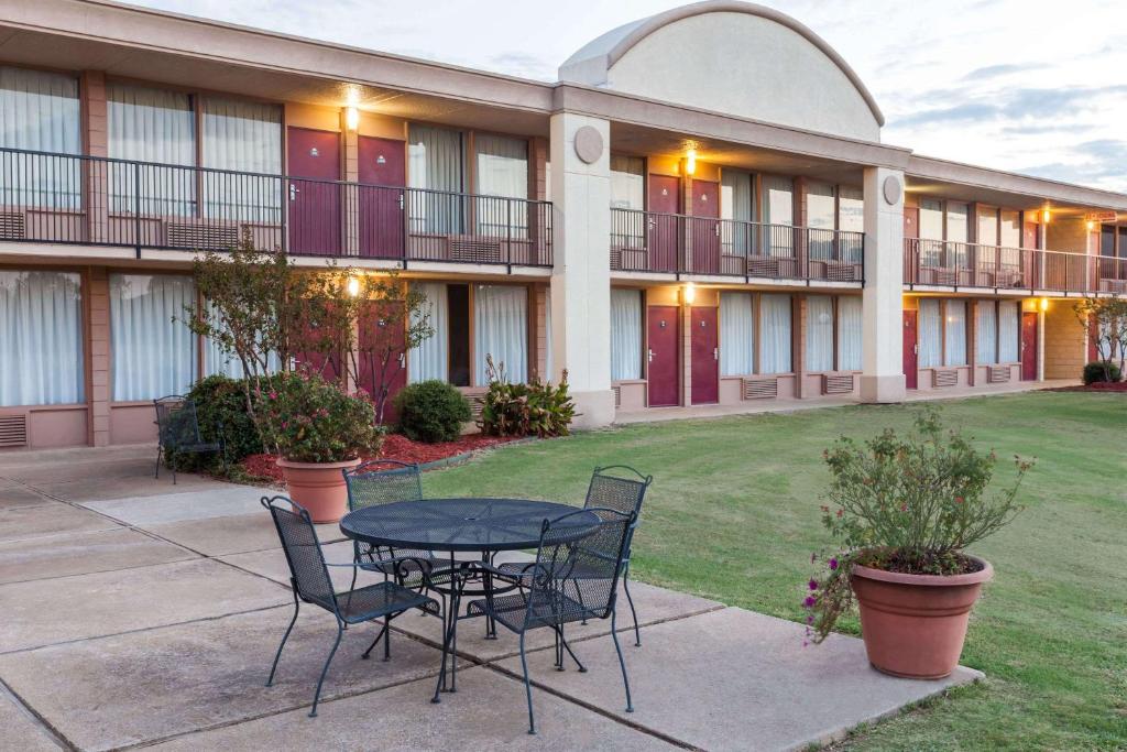 une terrasse avec une table et des chaises devant un bâtiment dans l'établissement Days Inn by Wyndham Hillsboro TX, à Hillsboro