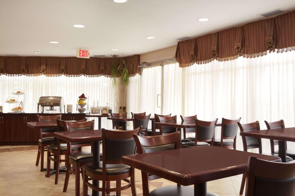 a dining room with wooden tables and chairs at Days Inn & Suites by Wyndham Langley in Langley